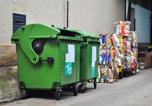 Labeled recycling bins for paper, glass, plastics and food waste in an office